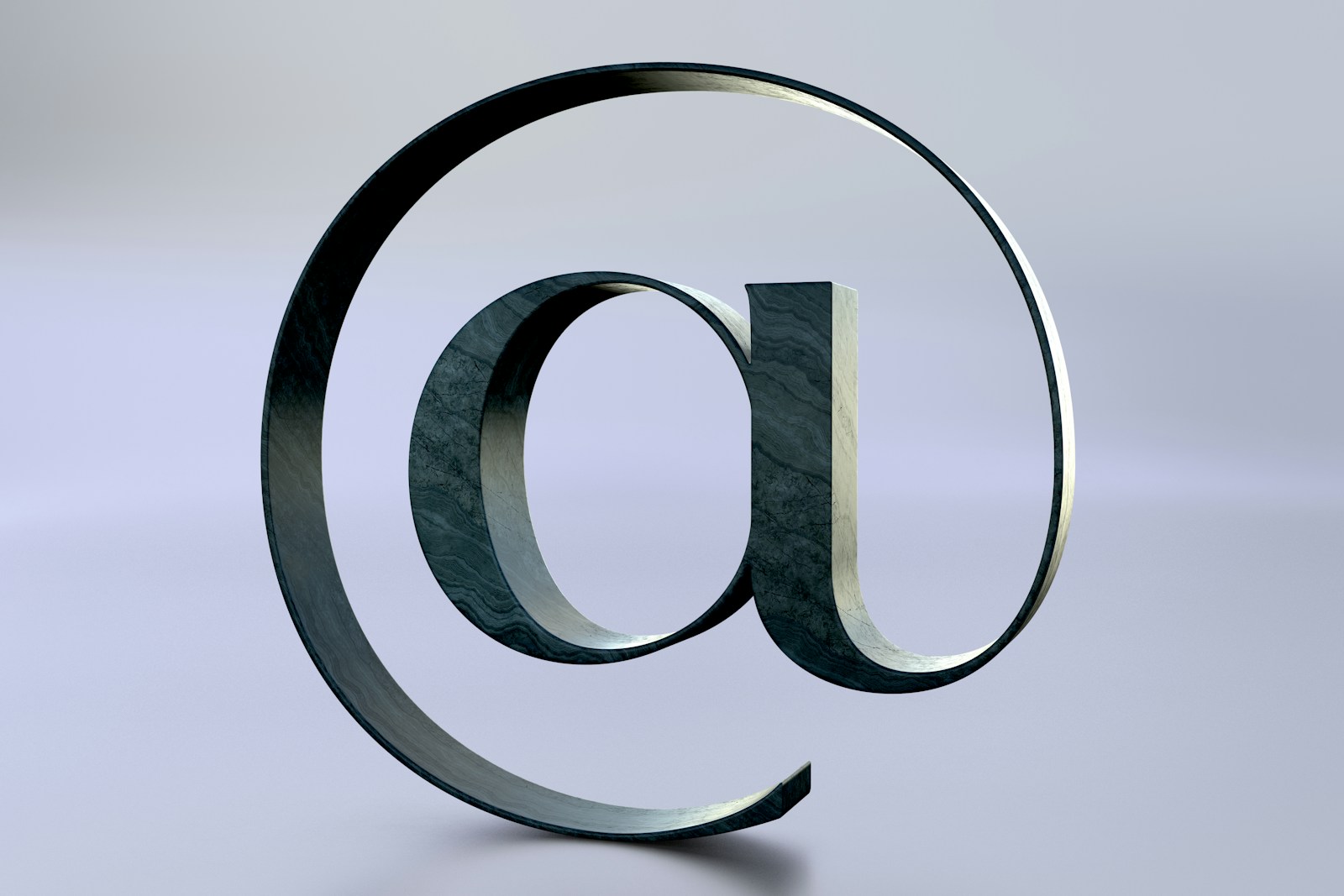 An at symbol is seen on a reflective surface.